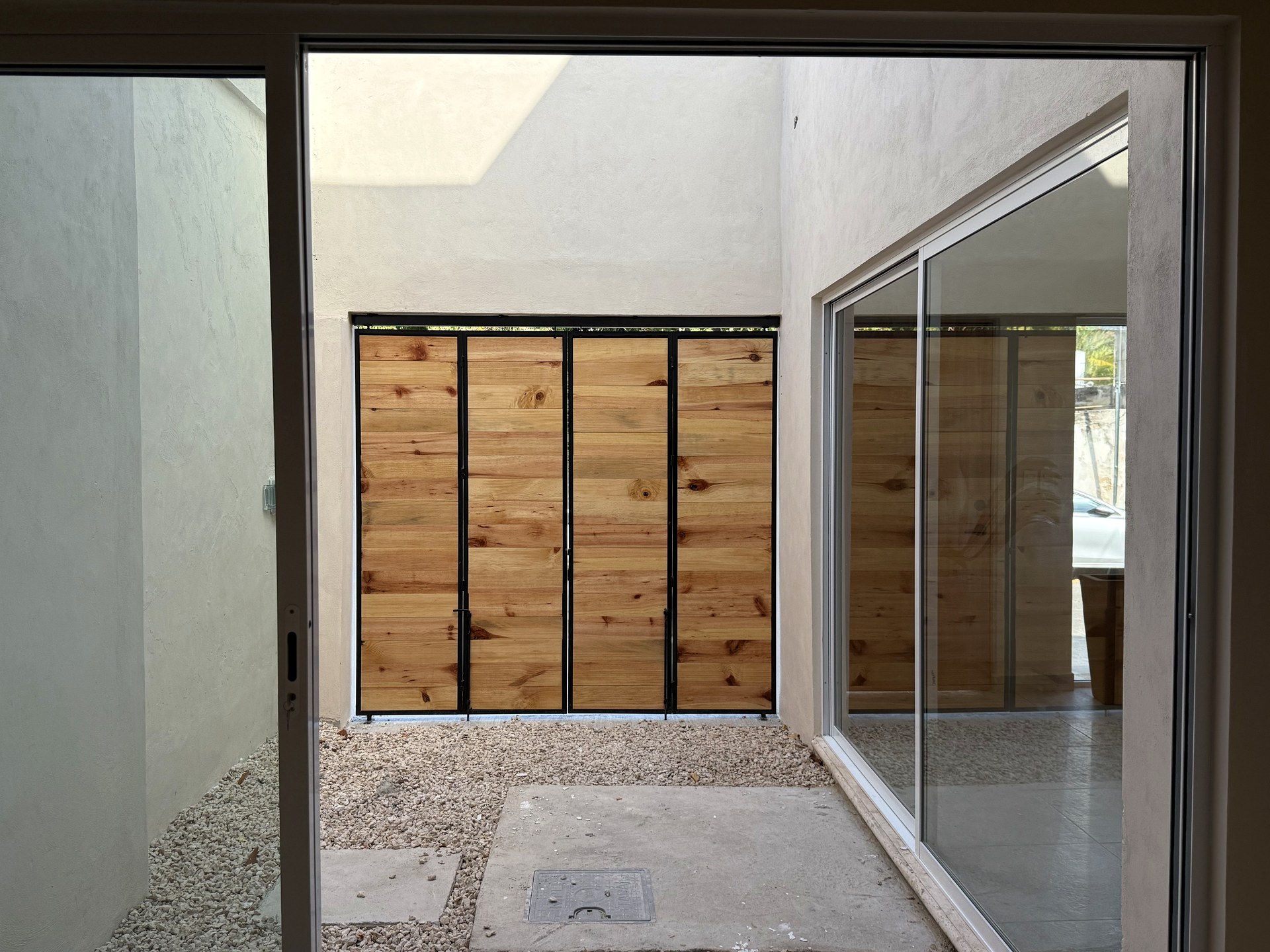 Casa Suspiro — glass doors framing the courtyard and pool from interior