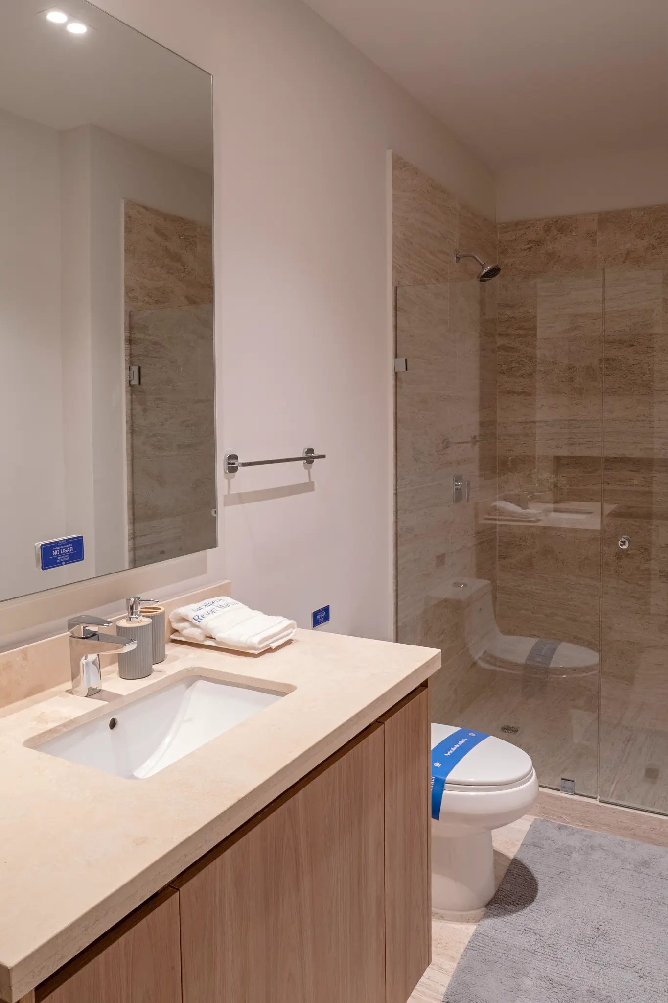 Bonanza B-707 — bathroom with marble walls and glass shower enclosure